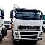 Volvo FM 400 6x4 truck tractor with black mesh stone guard on windscreen, front view in dealership