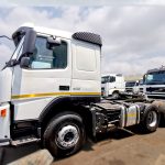 White Volvo FM 400 6x4 horse with black-and-white striped sunvisor, 400 badge visible, side profile